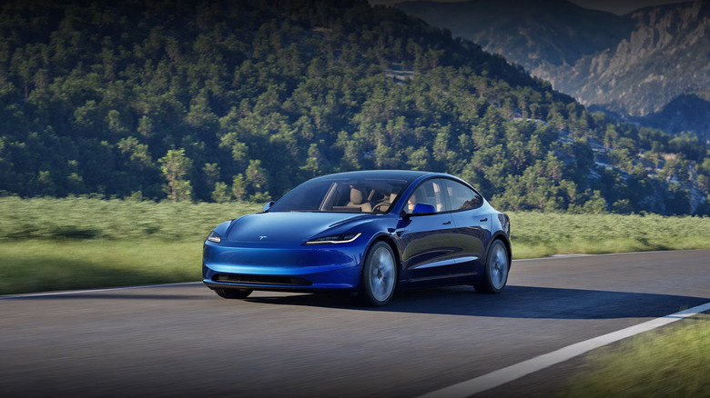 A blue 2025 Tesla Model 3 driving