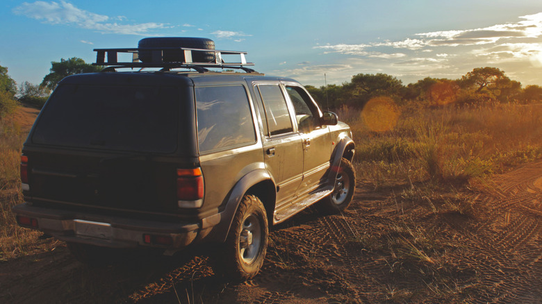 A 1997 Ford Explorer SUV parked off-road with the sun in the background.