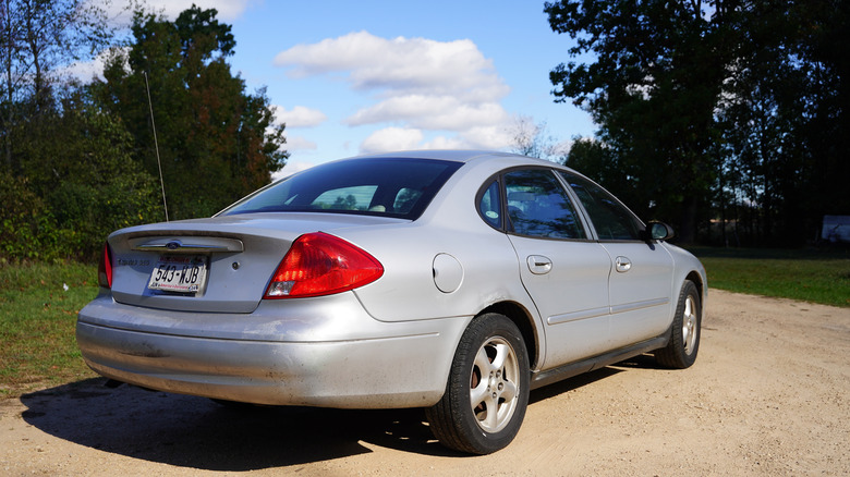 A late 90s/early 2000s silver Ford Taurus photographed from the rear three-quarter area