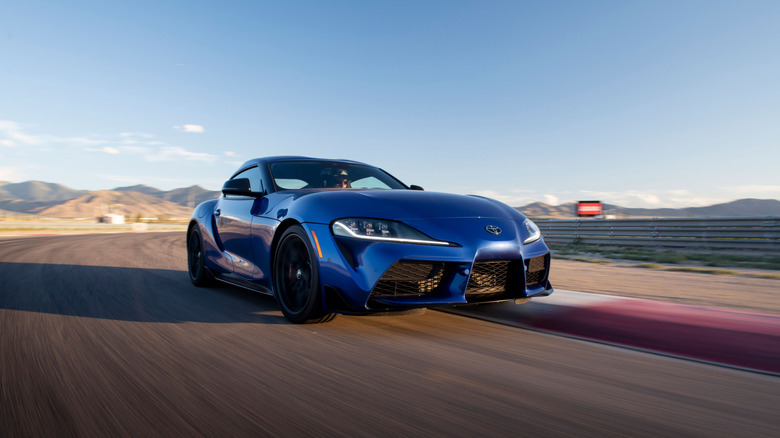 2026 Toyota GR Supra driving on racetrack, front-right 3/4 view