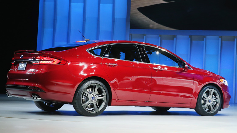Rear 3/4 view of red Ford Fusion sport on display at auto show.