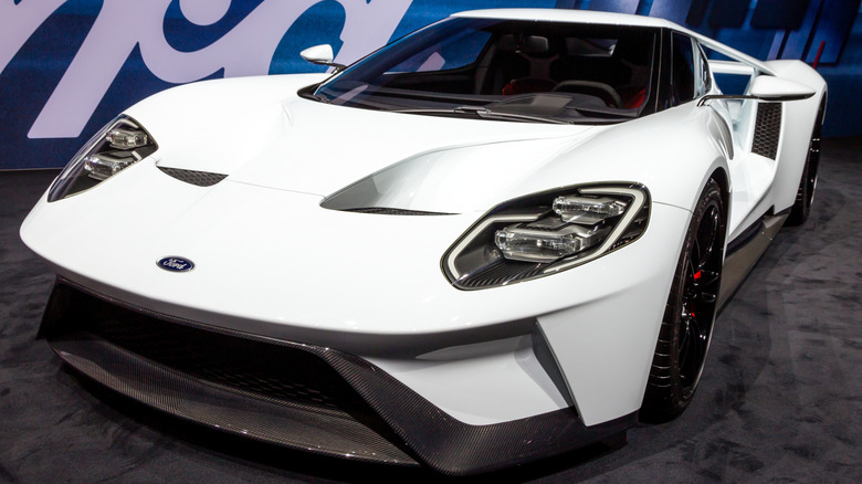 Front 3/4 view of white Ford GT on display at auto show booth.