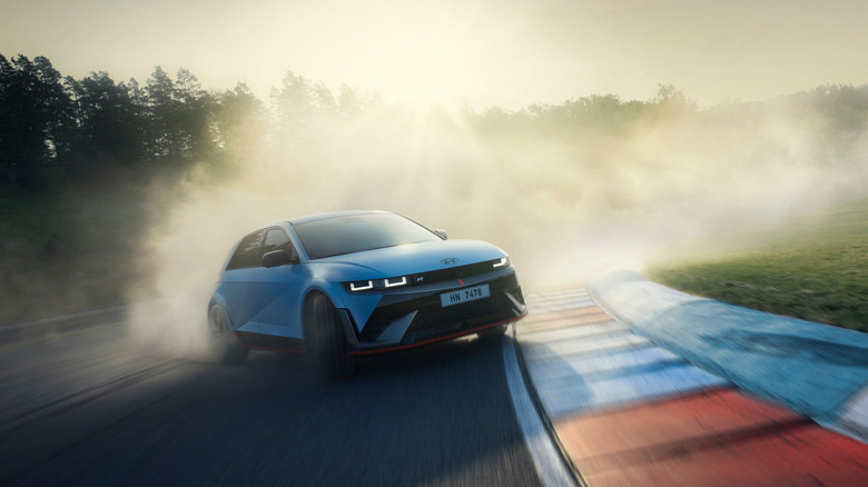 Hyundai Ioniq 5 N drifting around corner at racing circuit, front-right view