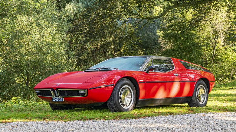 A Maserati Bora sports car on display on a patch of lawn at an outdoor car show.