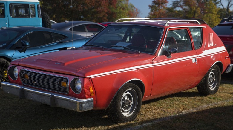 a red AMC Gremlin on a grass parking lot