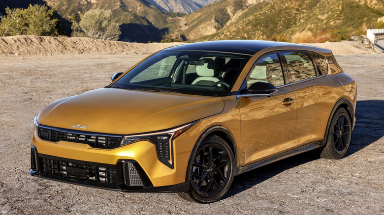 Front 3/4 view of 2026 Kia K4 hatchback in mountainous setting