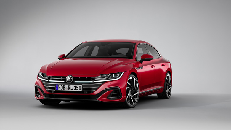Red 2021 Volkswagen Arteon hatchback sedan seen from front left in a studio