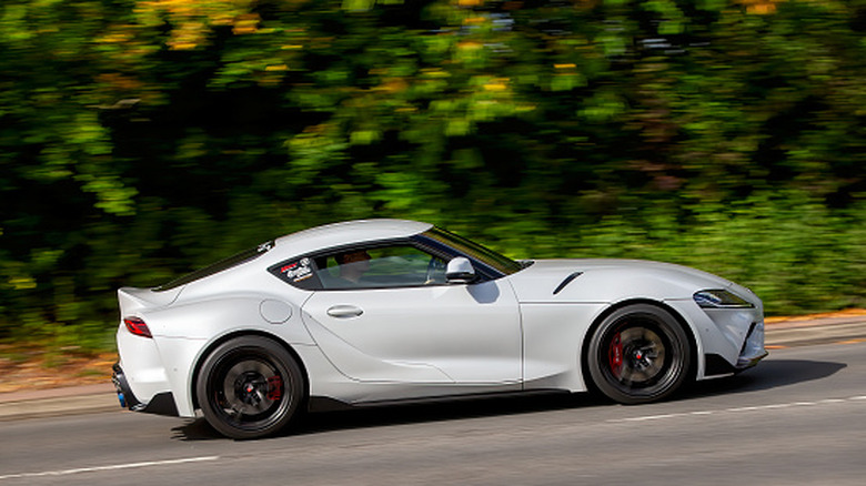 A white Toyota GR Supra speeding on a road