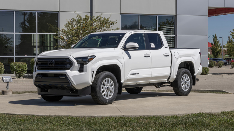 A white Toyota Tacoma parked in front of a dealership