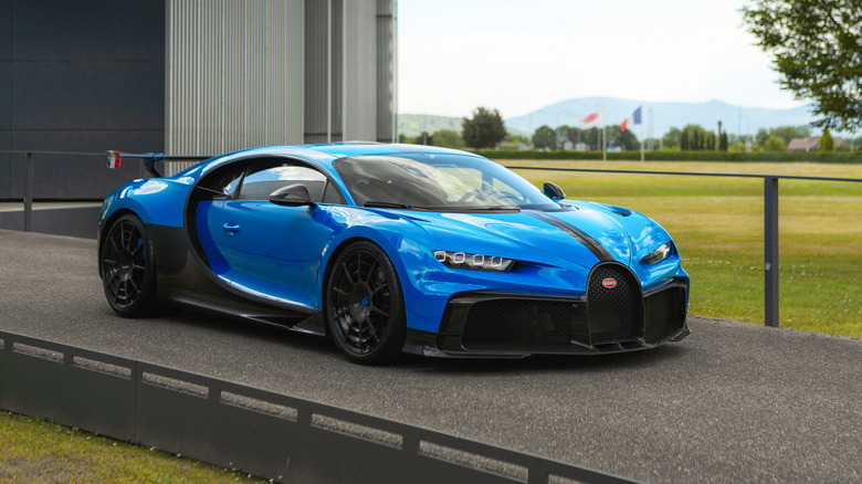 Bugatti Chiron Super Sport in blue outside a factory, front 3/4 view