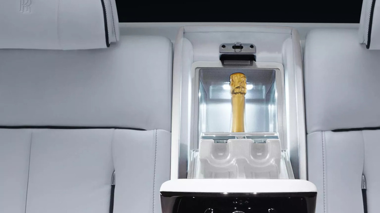 The rear seat of a Rolls-Royce vehicle with a luxurious built-in mini fridge