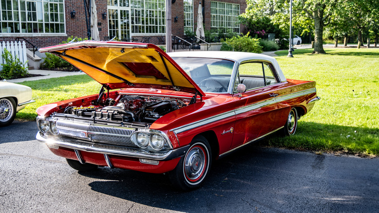 1962 Oldsmobile Jetfire parked with hood open, front-left 3/4 view