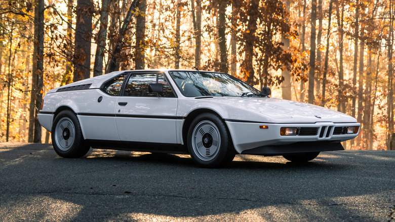 White BMW M1 parked in a forest during golden hour