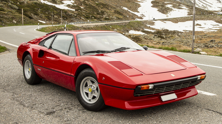 Red Ferrari 308 GTB "Vetroresina" parked at the side of a mountain road