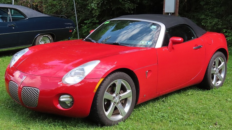Red Pontiac Solstice parked in a field