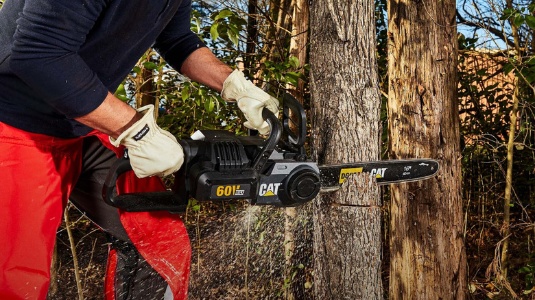Professional using a CAT 60V Max chainsaw