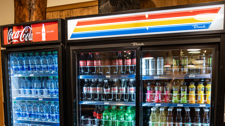 Water and bottled drinks stocked inside three commercial coolers.
