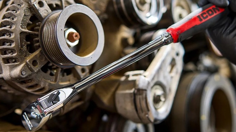 Person using Icon G2 ⅜-inch Drive 14-inch Long Locking Flex Ratchet on an engine