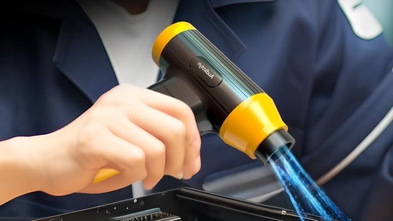 person using compressed air duster