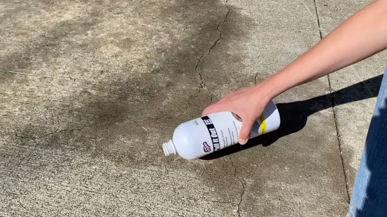 woman putting stain remover on concrete