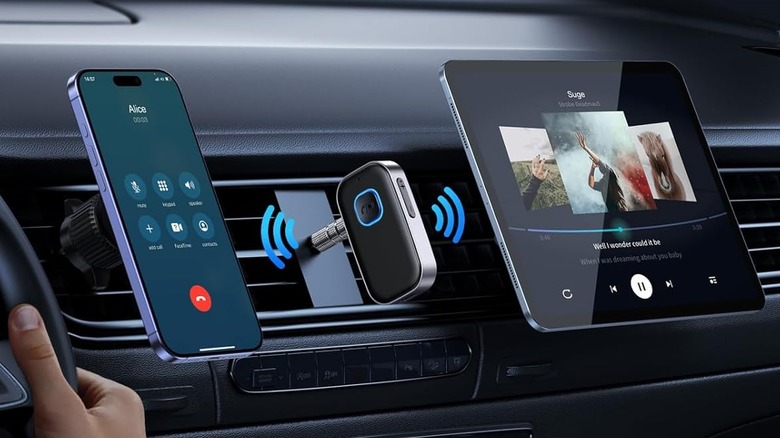 bluetooth receiver mouted on car dash next to a phone and tablet.