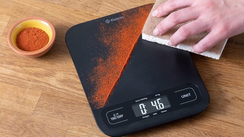 Black food scale with spices spilled