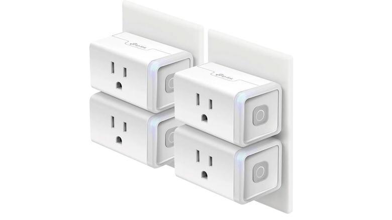 Four Kasa smart plugs attached to wall sockets on a white background
