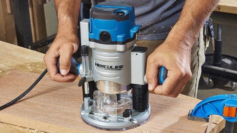 Person using Hercules 12 Amp Variable Speed Fixed Base Router on oak board