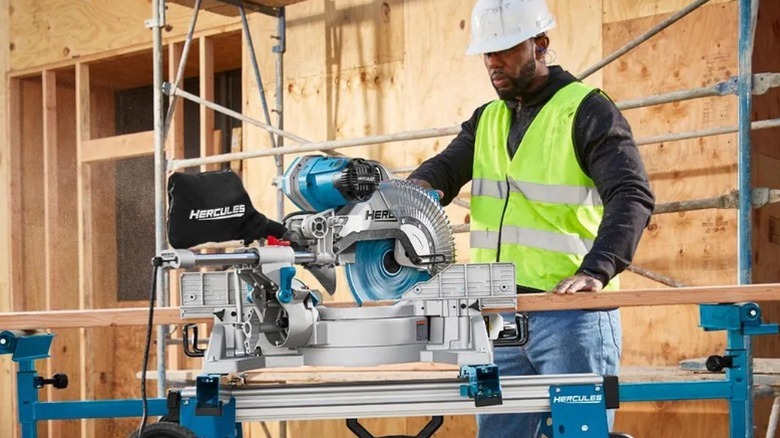 Constructing worker cutting 2x4 with Hercules 15 Amp 12-inch Dual-Bevel Miter Saw