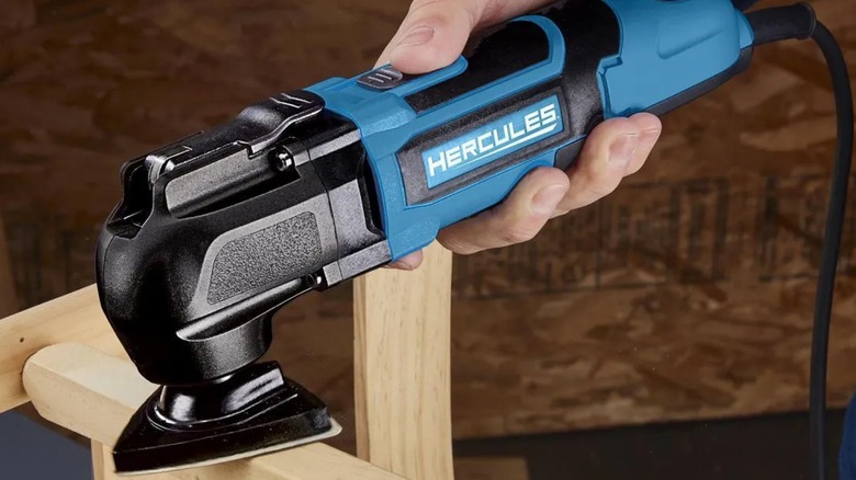 Person sanding chair brace with Hercules 3.5 Amp Variable Oscillating Multi-Tool