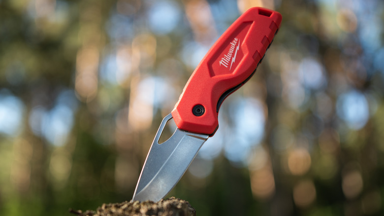 A Milwaukee knife stuck on a piece of wood
