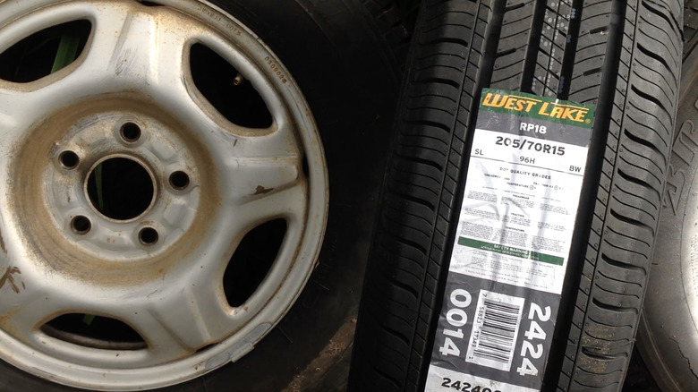 A car rim with a Westlake RP18 tire sticker on a tire next to it.