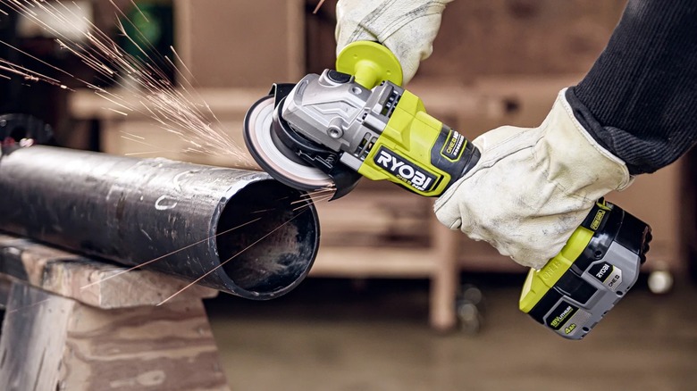 Person using  Ryobi 18V One+ HP 4 ½-inch Angle Grinder to grind metal pipe