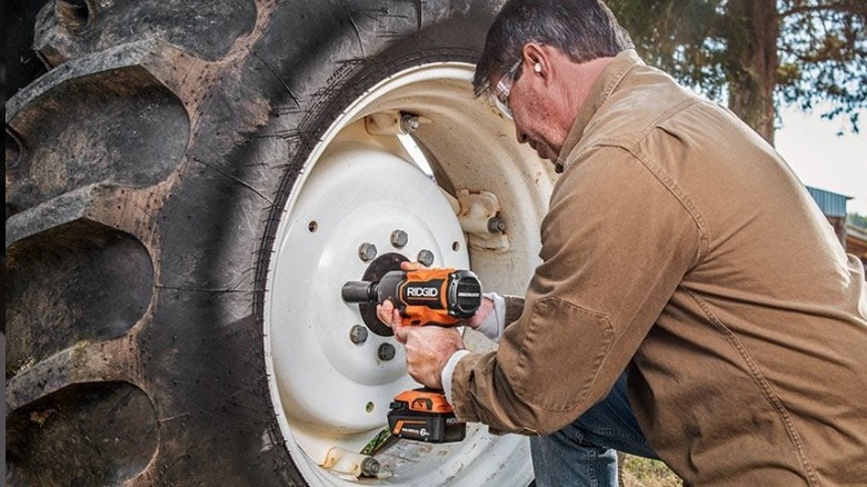 Person using Ridgid 18V Brushless ½-inch High-Torque Impact Wrench on tractor tire