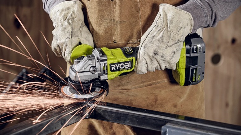 Person using  Ryobi 18V One+ HP 4 ½-inch Angle Grinder to grind metal pipe