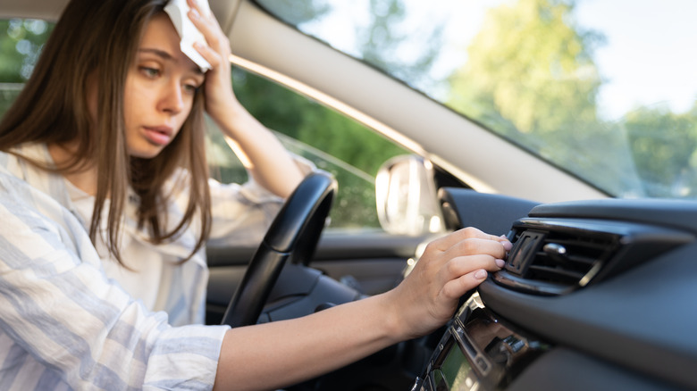 woman turning on AC hot car