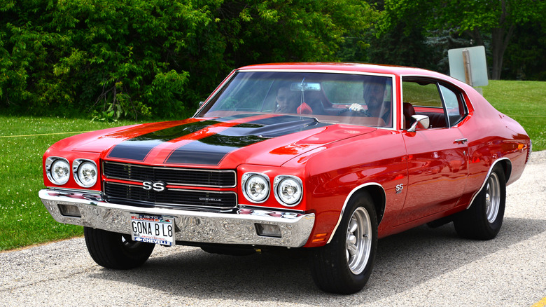 Red and black 1970 Chevrolet Chevelle SS 454 driving on country road
