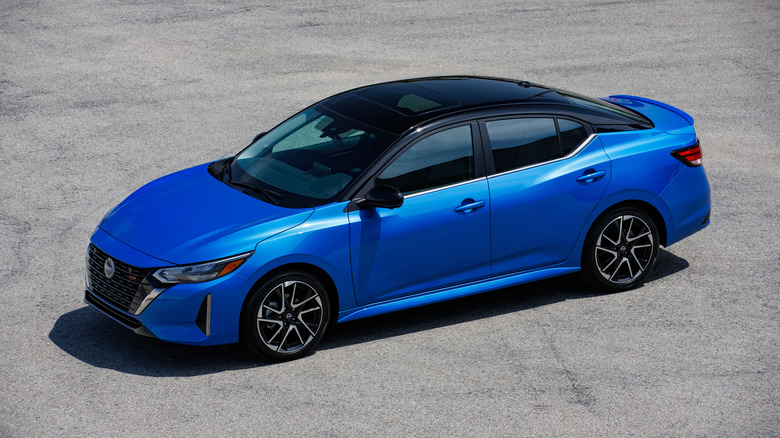 Blue 2025 Nissan Sentra seen from above left against a plain paved background