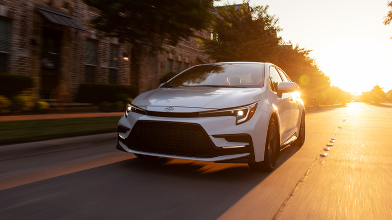 White 2025 Toyota Corolla XSE seen from front left on a city street at sunrise
