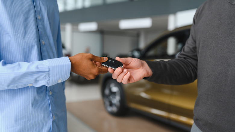 Salesperson giving a buyer new car keys