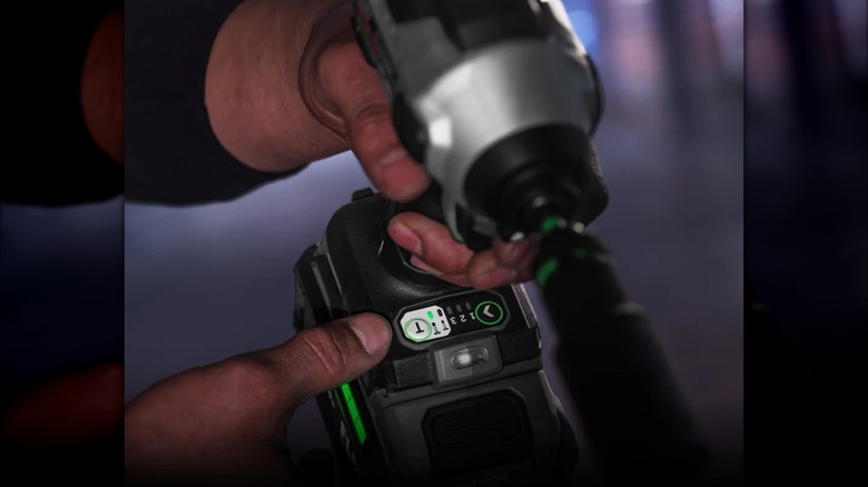 Close-up of hands inspecting the controls on a Flex 24V ¼-inch hex impact driver