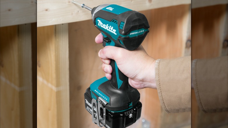 Person drilling into wood with a Makita 18V LXT cordless impact driver