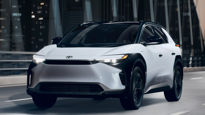 2025 Toyota bZ4X driving at night on bridge, front-left view