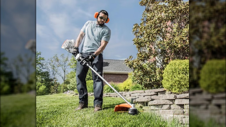 Landscaper cutting grass edge with Stihl weed eater