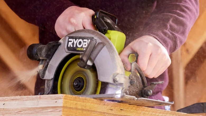 Person using Ryobi One+ HP 18V 7 ½-inch Circular Saw to cut plywood