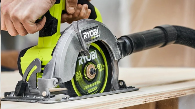 Person using Ryobi One+ HP 18V Brushless Compact 6 ½-inch Circular Saw on plywood