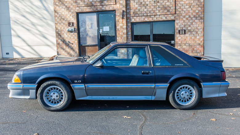 Blue and gray 1988 Mustang GT parked in front of a building