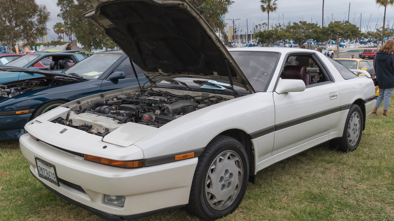 White 1988 Toyota Supra at a car show with the hood open