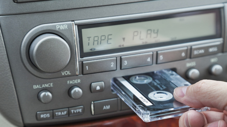 Person inserting cassette into automotive head unit