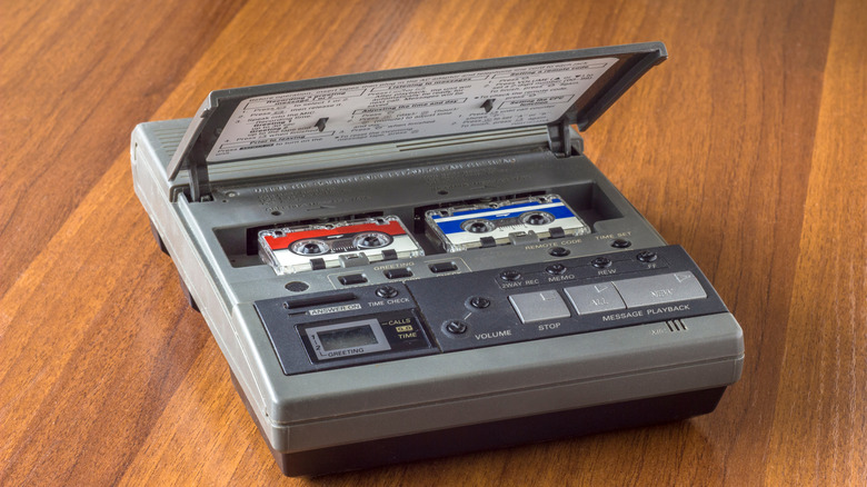 A vintage answering machine open with two small cassette tapes visible